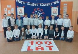 Dzieci z grupy Marzyciele (Borówko Stare) w odświętnych strojach na tle gazetki z napisem  (photo)